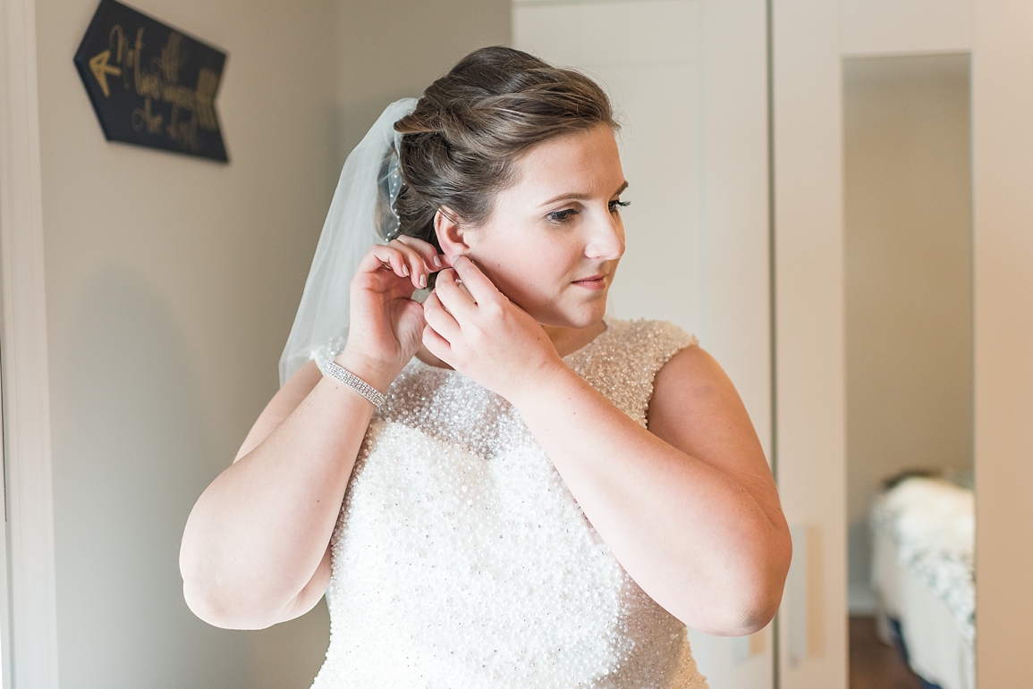 Bride putting on earrings
