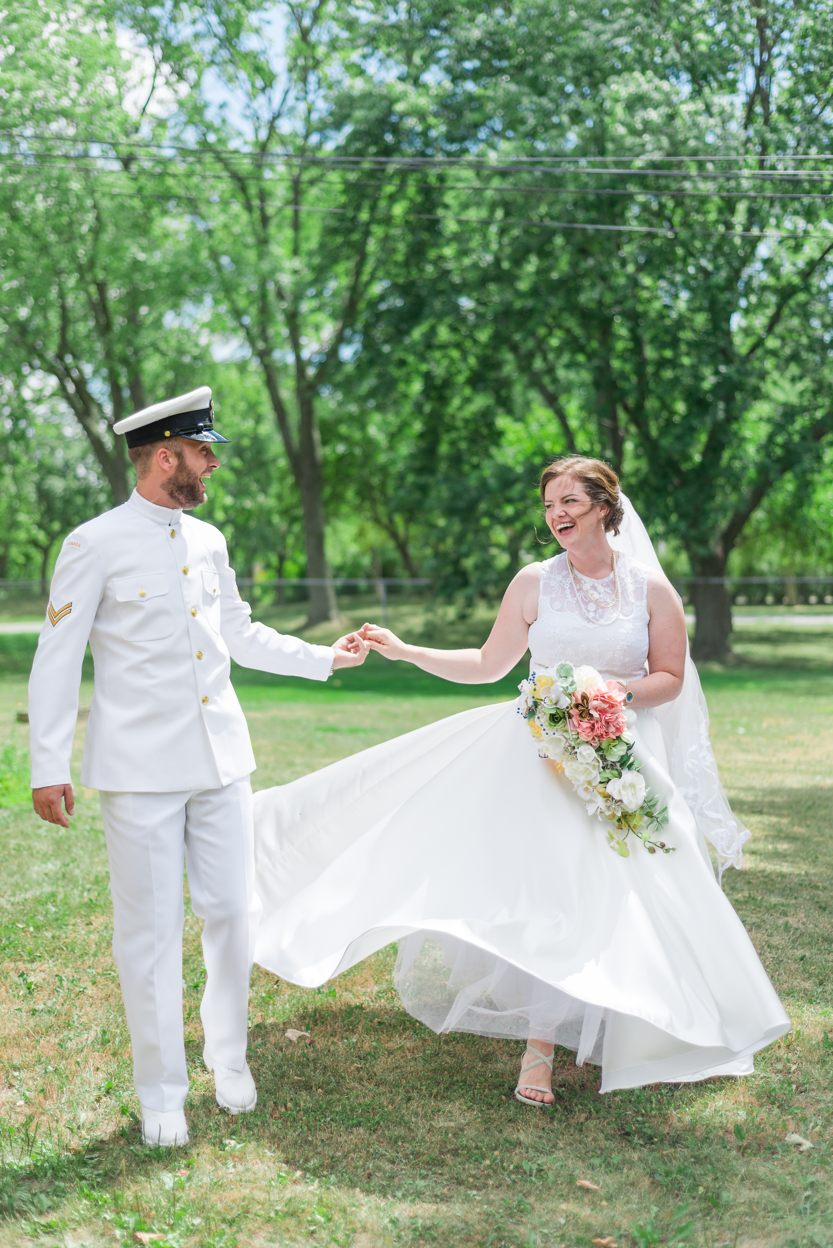 navy whites groom spins bride in field