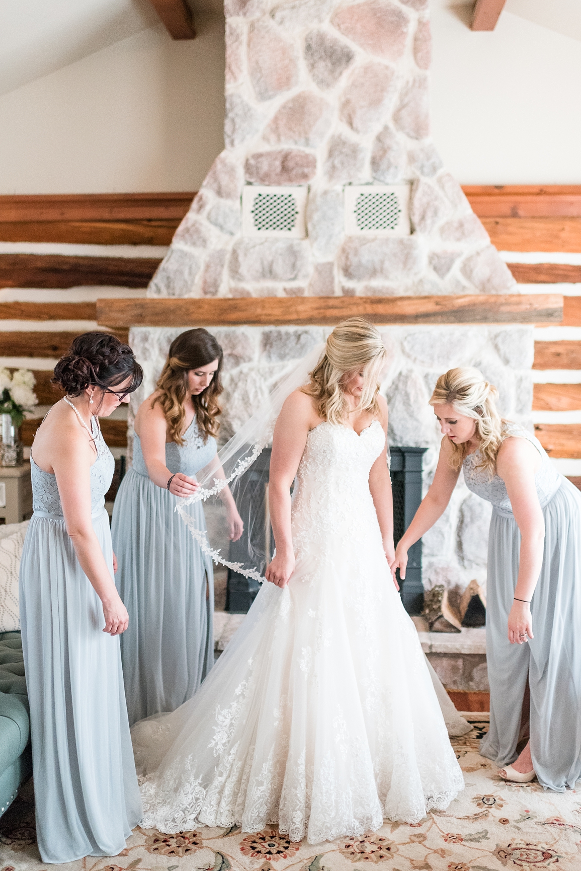 Bride getting into dress with bridesmaids