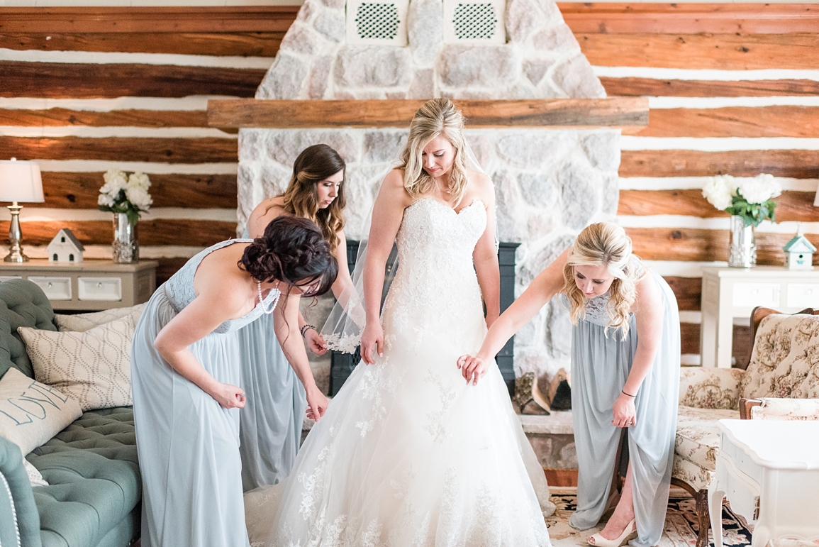 bride getting into dress with bridesmaids